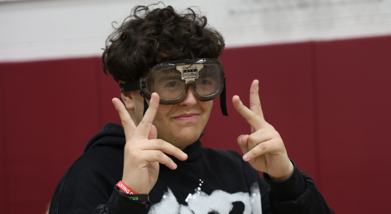 A student wearing vision impairment goggles